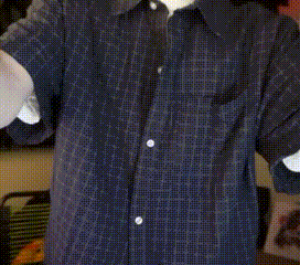 a man wearing a blue shirt with white buttons on the sleeves