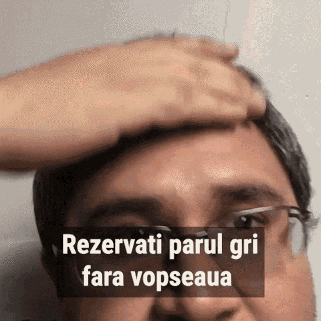 a man with glasses holds his hand to his forehead with the caption rezervati parul gri fara vopsea
