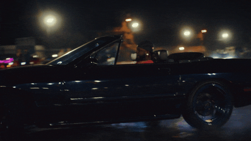a man is driving a black car at night
