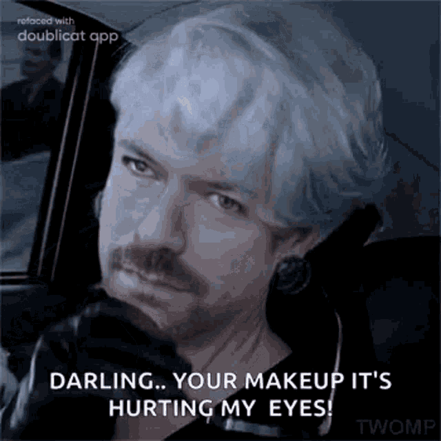 a man with white hair and a mustache is sitting in a car with a gun .