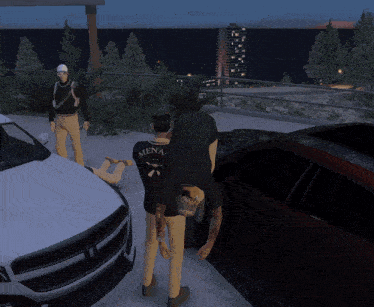 a man wearing a black shirt that says mena is standing next to a car