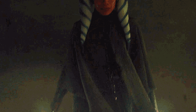 a woman wearing a striped headband is standing in the dark