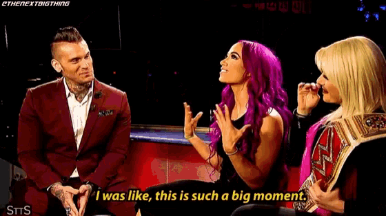 a woman with purple hair is talking to a man and another woman while sitting next to each other .