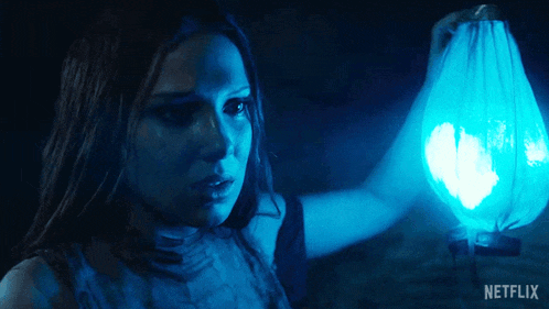 a woman is holding a blue lantern with a netflix logo on the bottom
