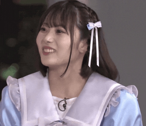 a girl with a blue bow in her hair smiles