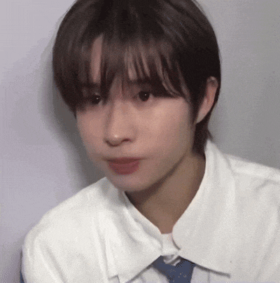 a close up of a person 's face with a white shirt and tie .
