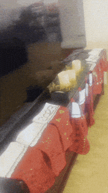 a blurred image of a table with a red table cloth and a few pieces of food on it
