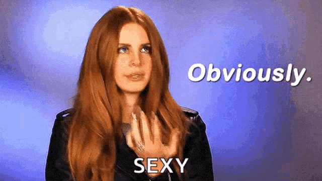 a woman with long red hair says obviously sexy in front of a blue background