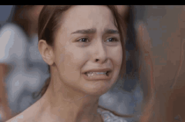 a close up of a woman 's face with a sad look on her face