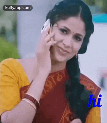 a woman in a yellow shirt is talking on a cell phone and smiling .