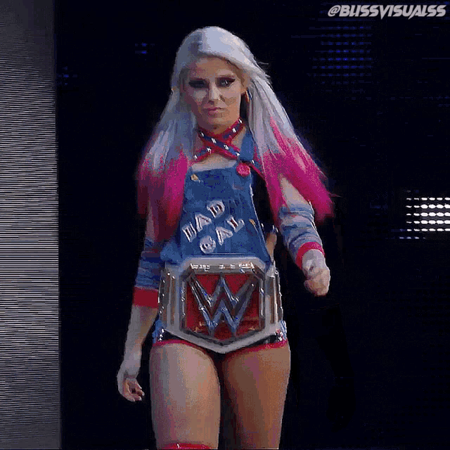 a female wrestler is wearing overalls and a bad gal shirt