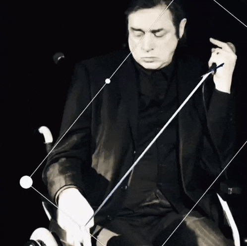 a man in a black suit is holding a sword