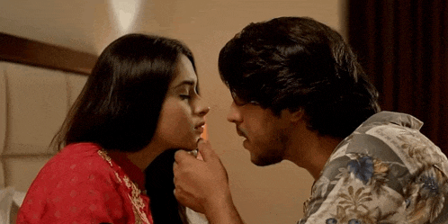 a man is lighting a woman 's cigarette with a lighter .