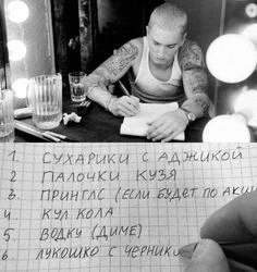 a man is sitting at a table writing on a piece of paper in a black and white photo .