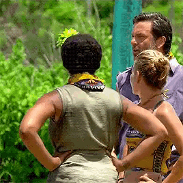 a man and two women are standing next to each other in a field .