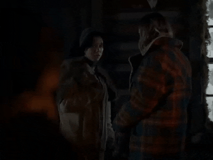 a man and a woman are standing in a dark room .
