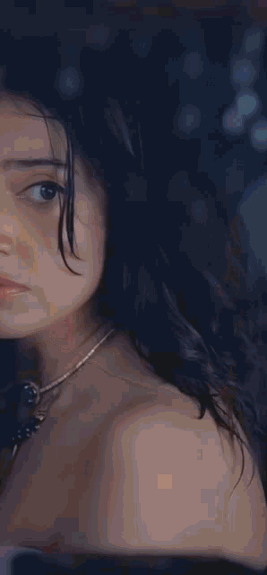 a close up of a woman 's face with a blurry background of lights behind her .