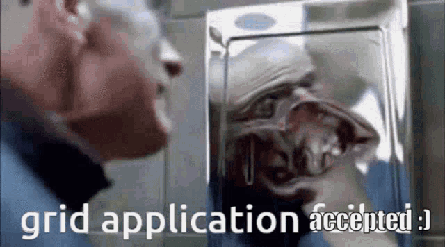 a man is looking at his reflection in a mirror with the words `` grid application accepted '' written on the bottom .