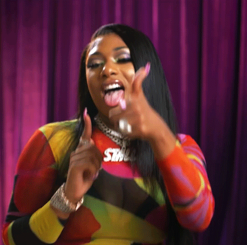 a woman wearing a necklace with the word swag on it is sticking her tongue out