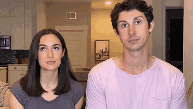 a man and woman are standing next to each other in a kitchen