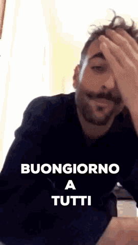 a man with a mustache is covering his face with his hand and the words buongiorno a tutti are above him