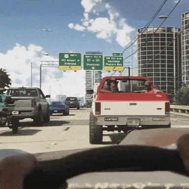 a red truck is driving down a highway with a green sign that says vc airport