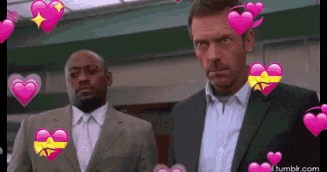two men standing next to each other with pink hearts surrounding them and tumblr.com in the corner