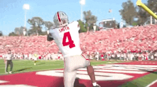 a football player with the number 4 on his jersey is throwing a ball on the field .