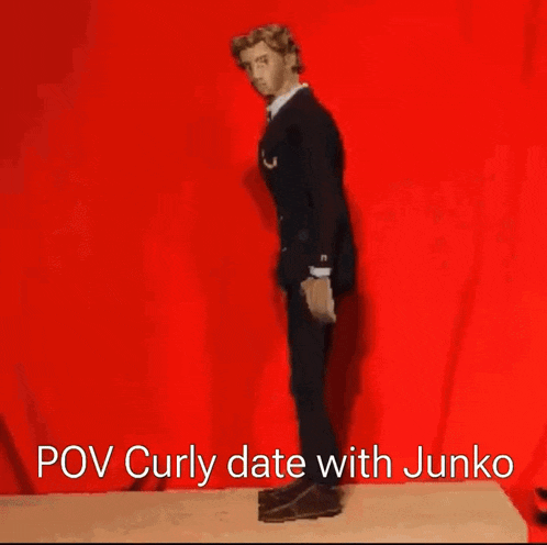a man in a suit and tie is standing in front of a red background with the caption pov curly date with junko