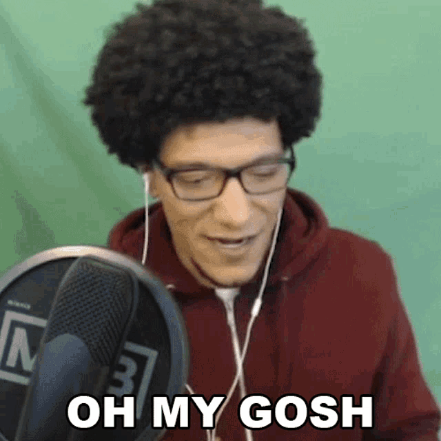 a man wearing glasses and headphones says oh my gosh in front of a microphone