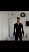a man is standing in a room with a white background .