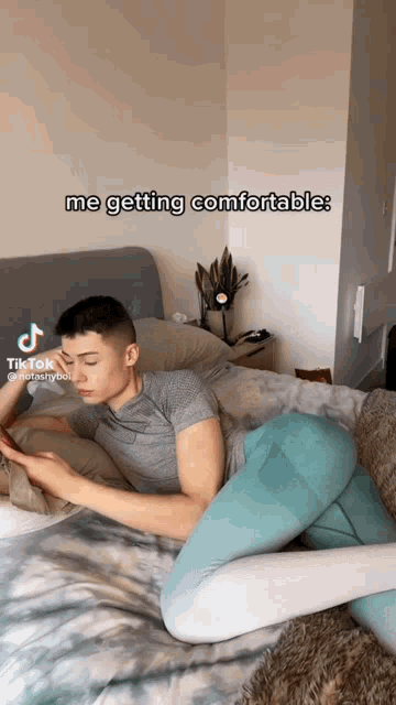 a man laying on a bed with the caption " me getting comfortable " on it