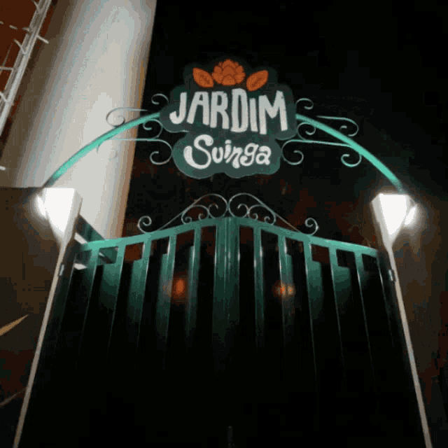a green gate with a sign that says " jardim suriga "