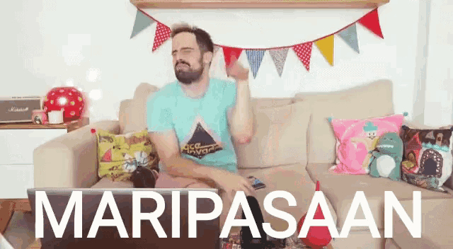 a man sitting on a couch with the word maripasaan written on the bottom