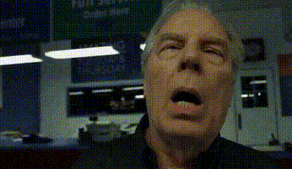 a close up of a man 's face with his mouth open in a room