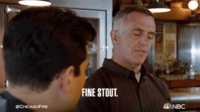 a man in a brown shirt says fine stout while talking to another man