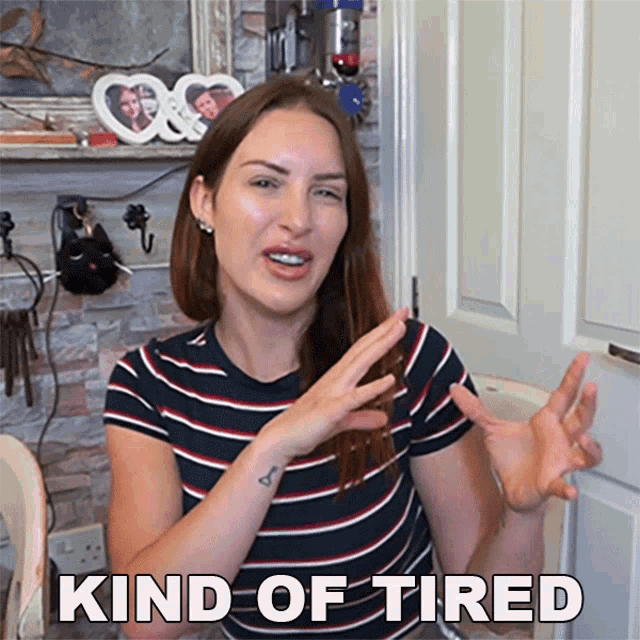 a woman in a striped shirt says " kind of tired " in front of a door
