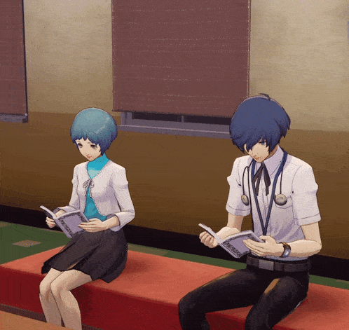 a man and a woman are sitting on a red couch reading books