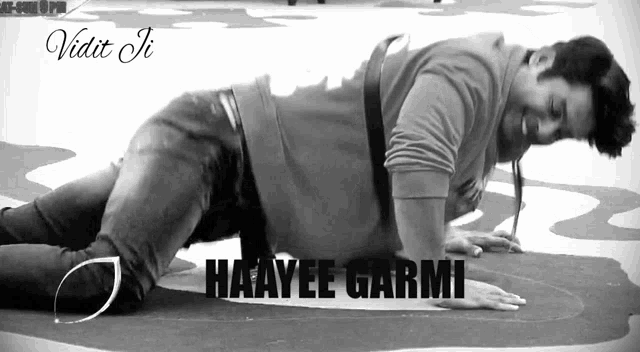 a black and white photo of a man doing push ups with the name haayyee garmi in the corner