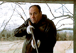 a man in a black jacket is holding a sword