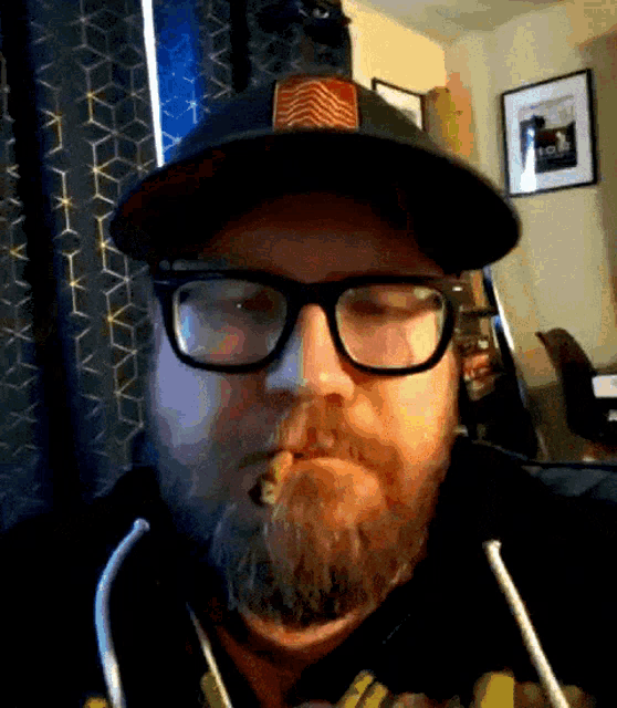 a man with a beard wearing glasses and a hat