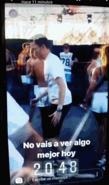 a phone screen shows a group of people dancing and says no vais a ver algo mejor hoy 20:48