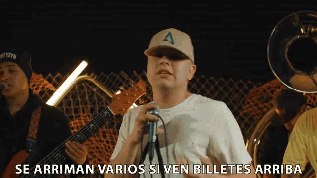 a man singing into a microphone with the words se arriman varios si ven billetes arriba