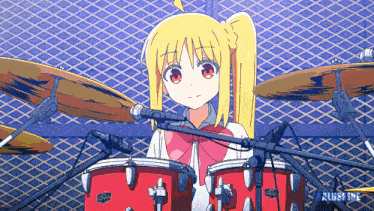 a girl is playing drums with the word ruby in the lower right corner