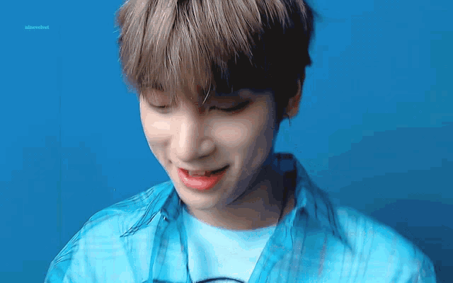 a close up of a person 's face with a blue shirt on