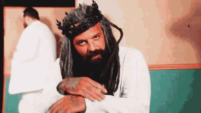 a man with dreadlocks is wearing a crown on his head .