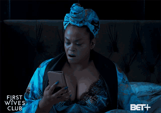 a woman laying in bed looking at her phone with the words youre bout to die above her