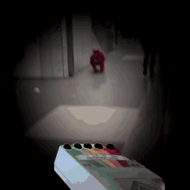 a person in a red suit is kneeling down in a hallway