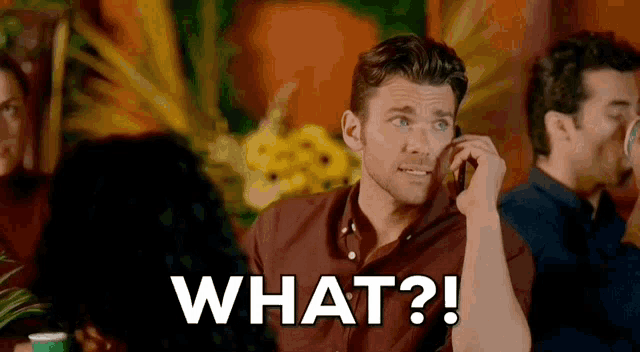 a man is talking on a cell phone and the words what are above him