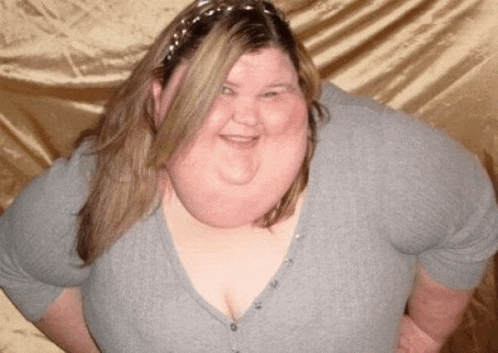 a woman with a very large neck and breasts is smiling for the camera
